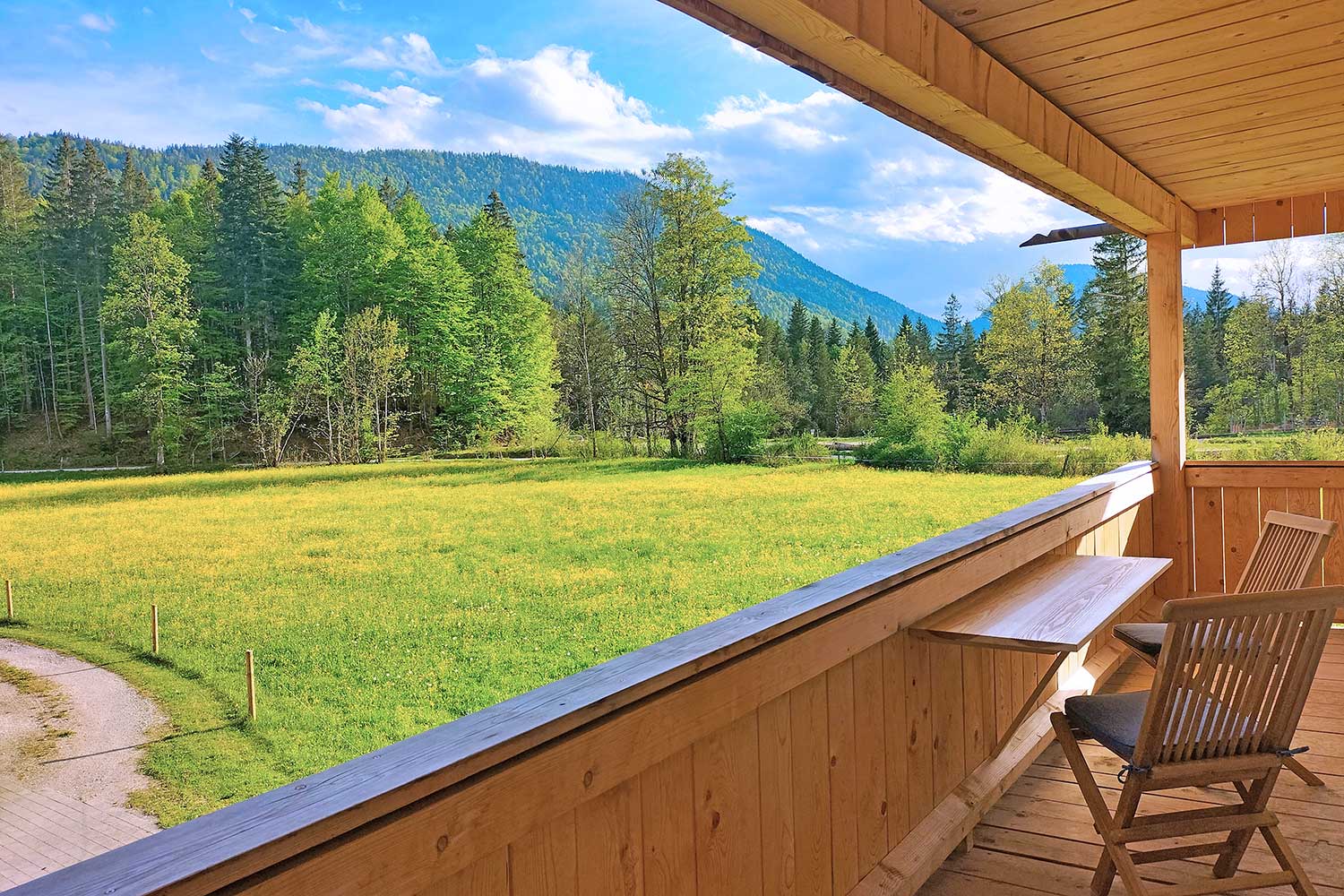 Naturhaus-Leger-Balkon-Aussicht-auf-Wiesen-Wald-und-Berge